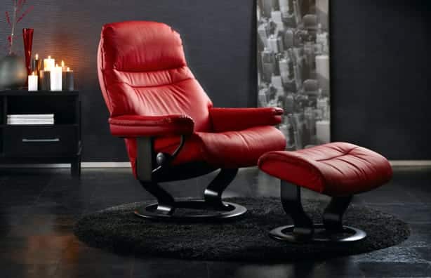 Contemporary red leather reclining accent chair and matching leather ottoman provide a pop of color in contrast to bold modern living room 