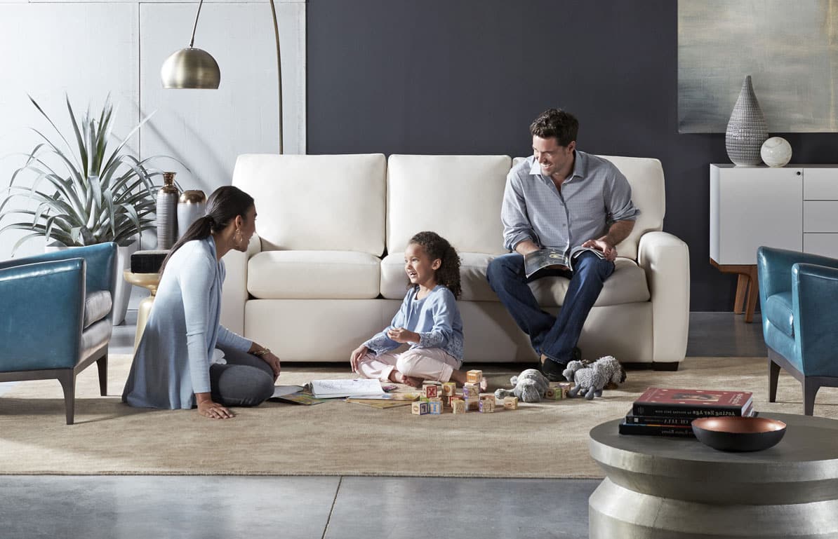 Family enjoying a modern sofa and leather accent chairs