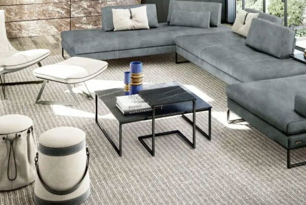 Black coffee table in modern living room styled with a gray couch and white chair.